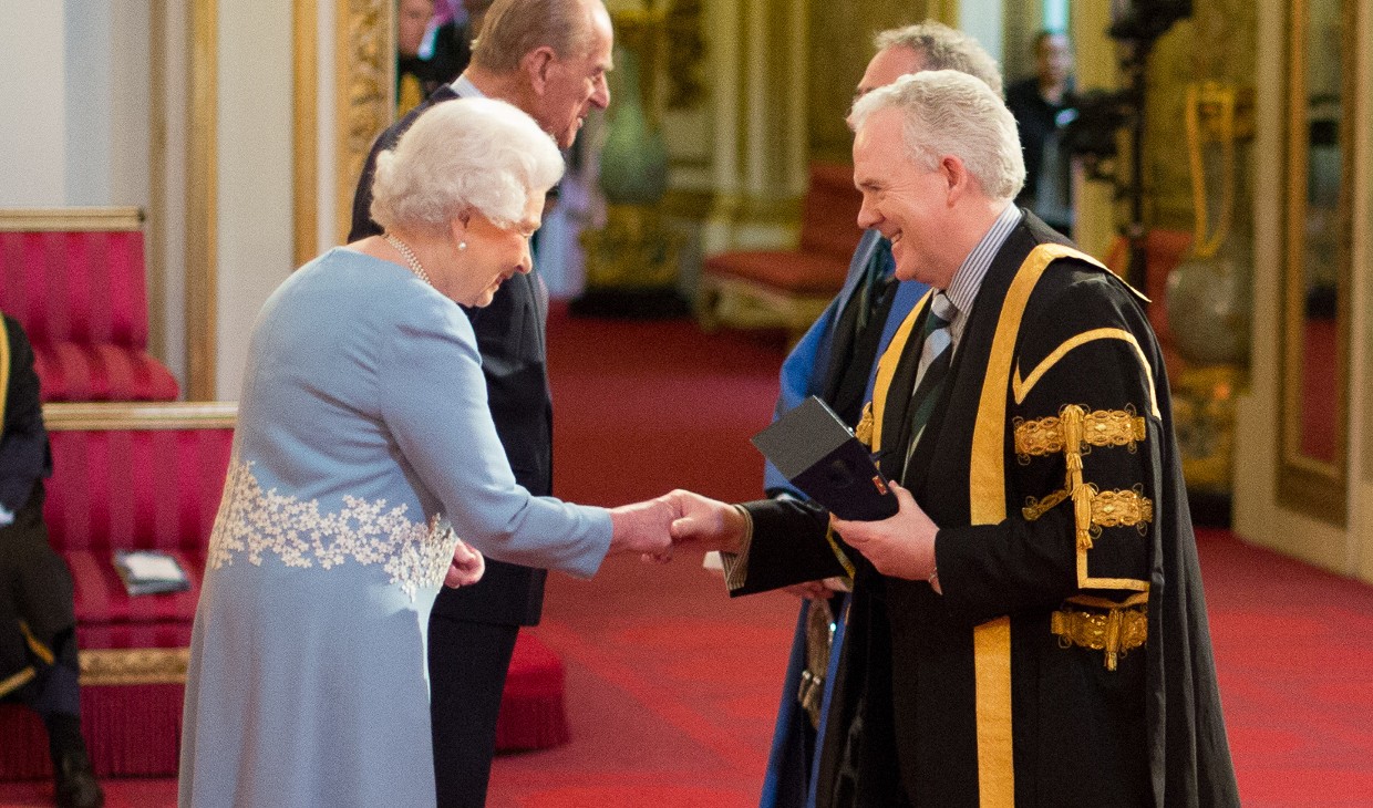 Professor Sir Gerry McCormac shakes the hand of Queen Elizabeth II at Buckingham Palace