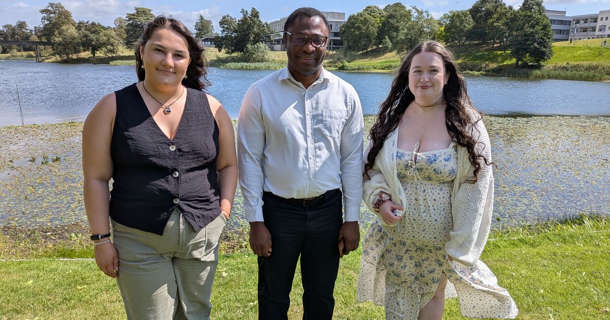 Mollie McGoran (left), Dr Damian Etone and Grace Fennell standing on the banks of Airthrey Loch at the University of Stirling