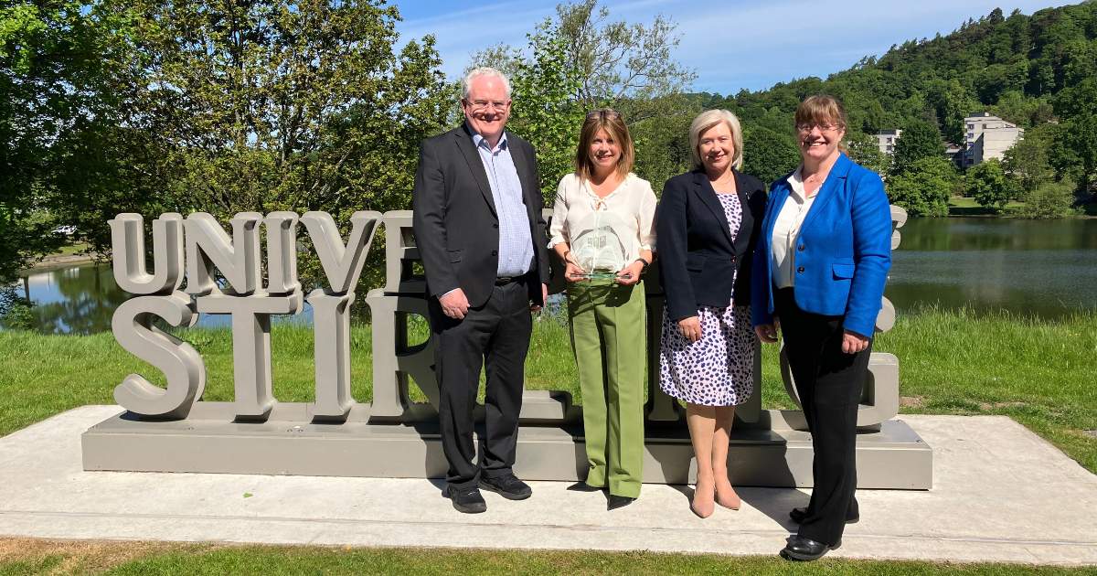 group of 4 people outside with blue sky and green grass