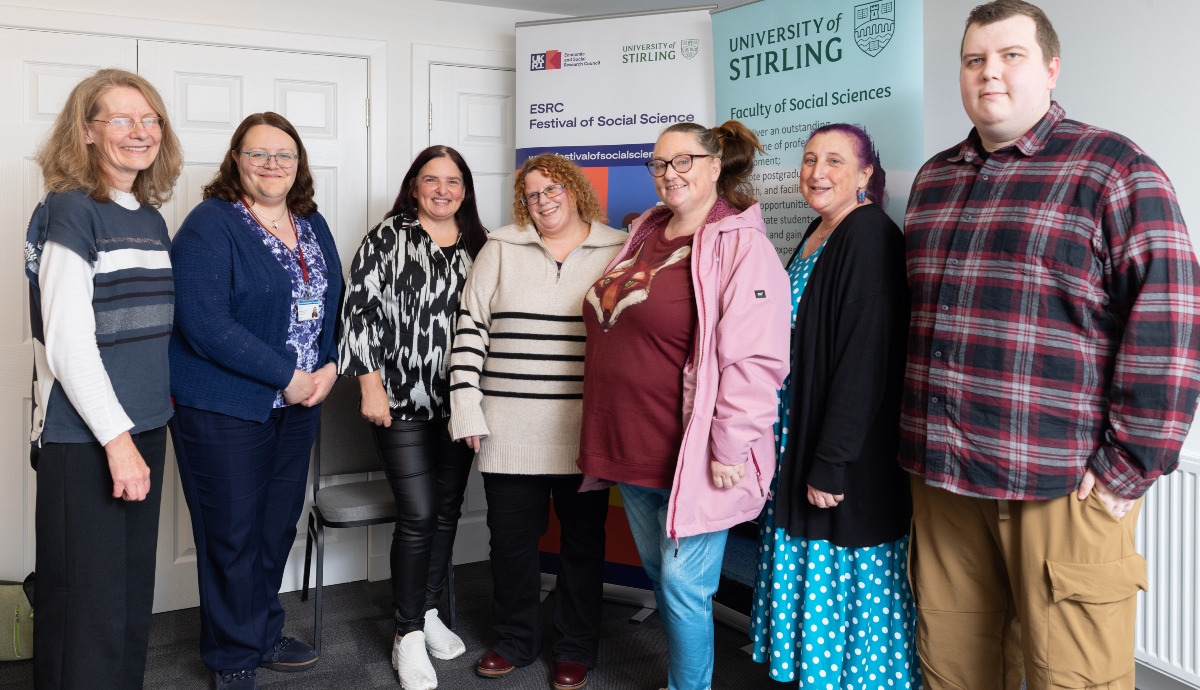 group of women and one man smiling in row